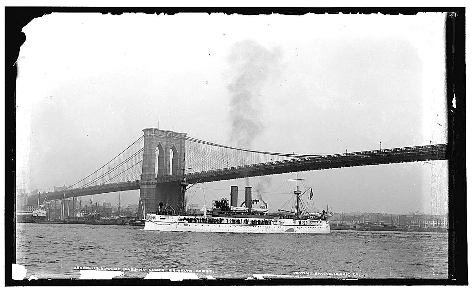 Крейсер «Мэн» проходит под Бруклинским мостом в Нью-Йорке